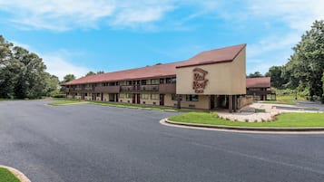 A Red Roof Inn with a red roof, beige exterior, and a parking lot.