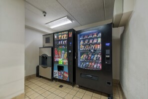 Två automater med ett varierat utbud av snacks och drycker, en övervakningskamera och ett klinkergolv.
