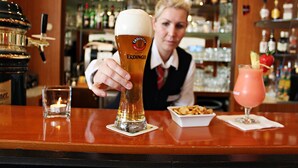A bar with a beer glass, a candle, and a cocktail. - PLAZA INN Berlin Charlottenburg (Berlin)