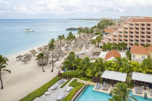 Un resort con playa, piscina y edificios de hotel.