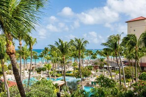 Un resort con piscina, palmeras y vista al océano.