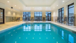An indoor swimming pool with clear water, surrounded by windows and seating areas. - Hampton Inn & Suites Newport/Cincinnati (Newport)