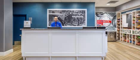 A reception desk with a blue wall and a 'Welcome to Newport' sign.