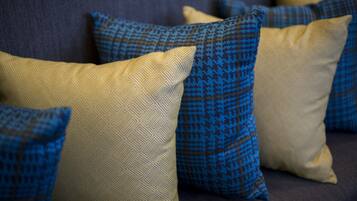A close-up of a sofa with patterned cushions in shades of blue and beige.