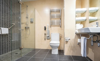 A modern bathroom with a shower, toilet, and sink.