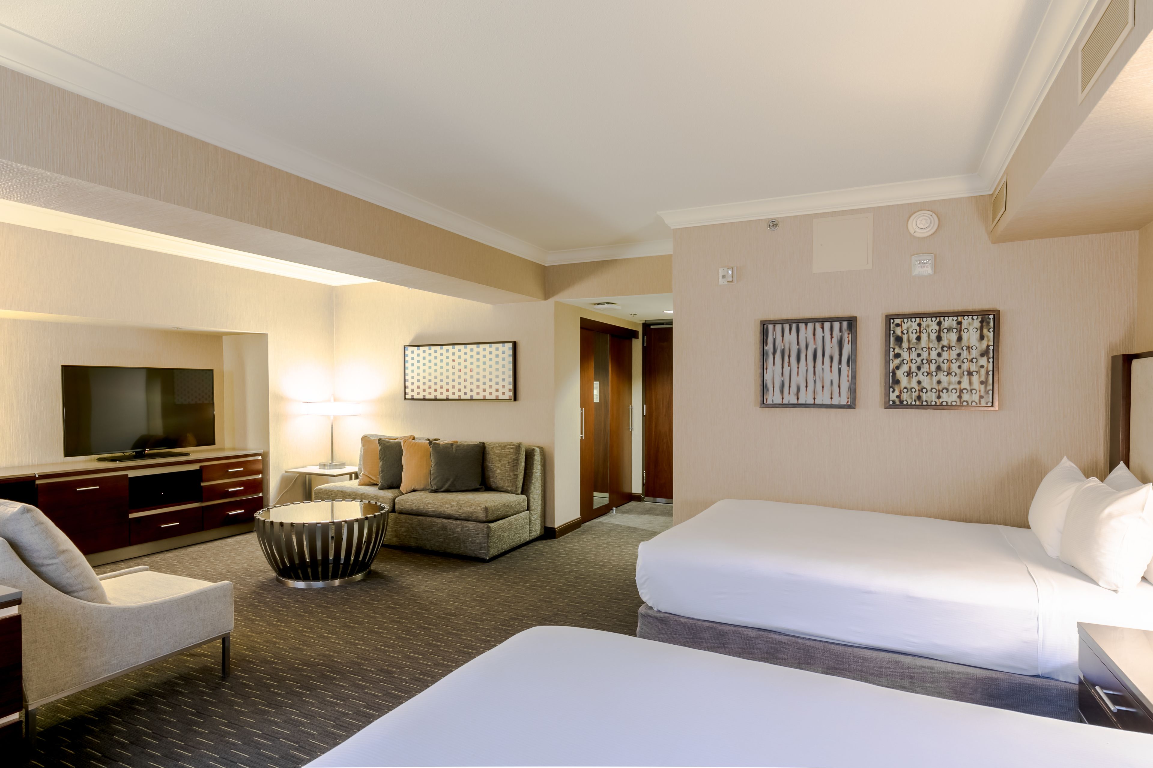 A hotel room with a bed, a sofa, a TV, and a desk.