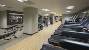 A gym with treadmills, weight machines, and benches.