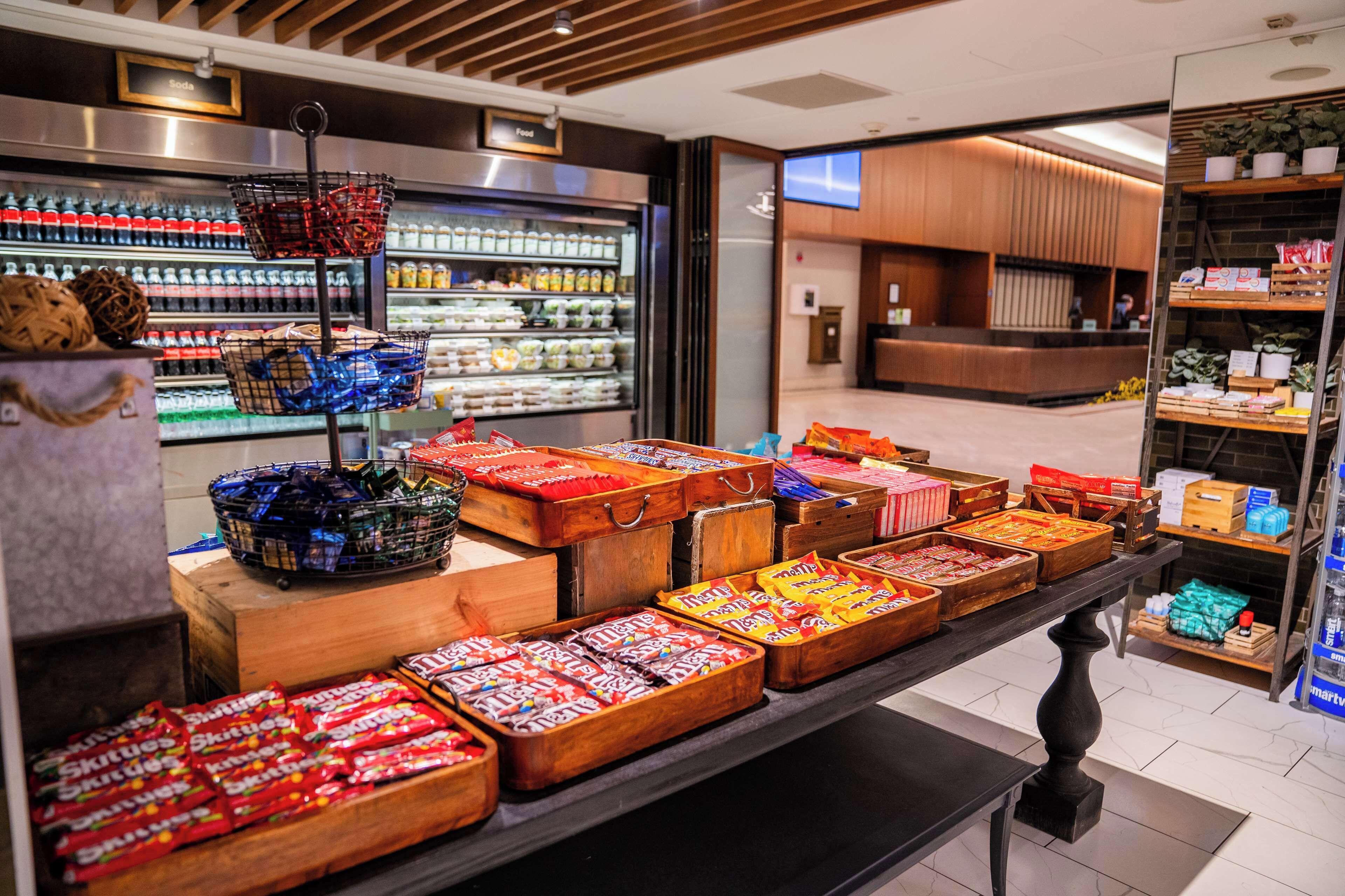 A candy display with various types of sweets in wooden boxes and baskets.