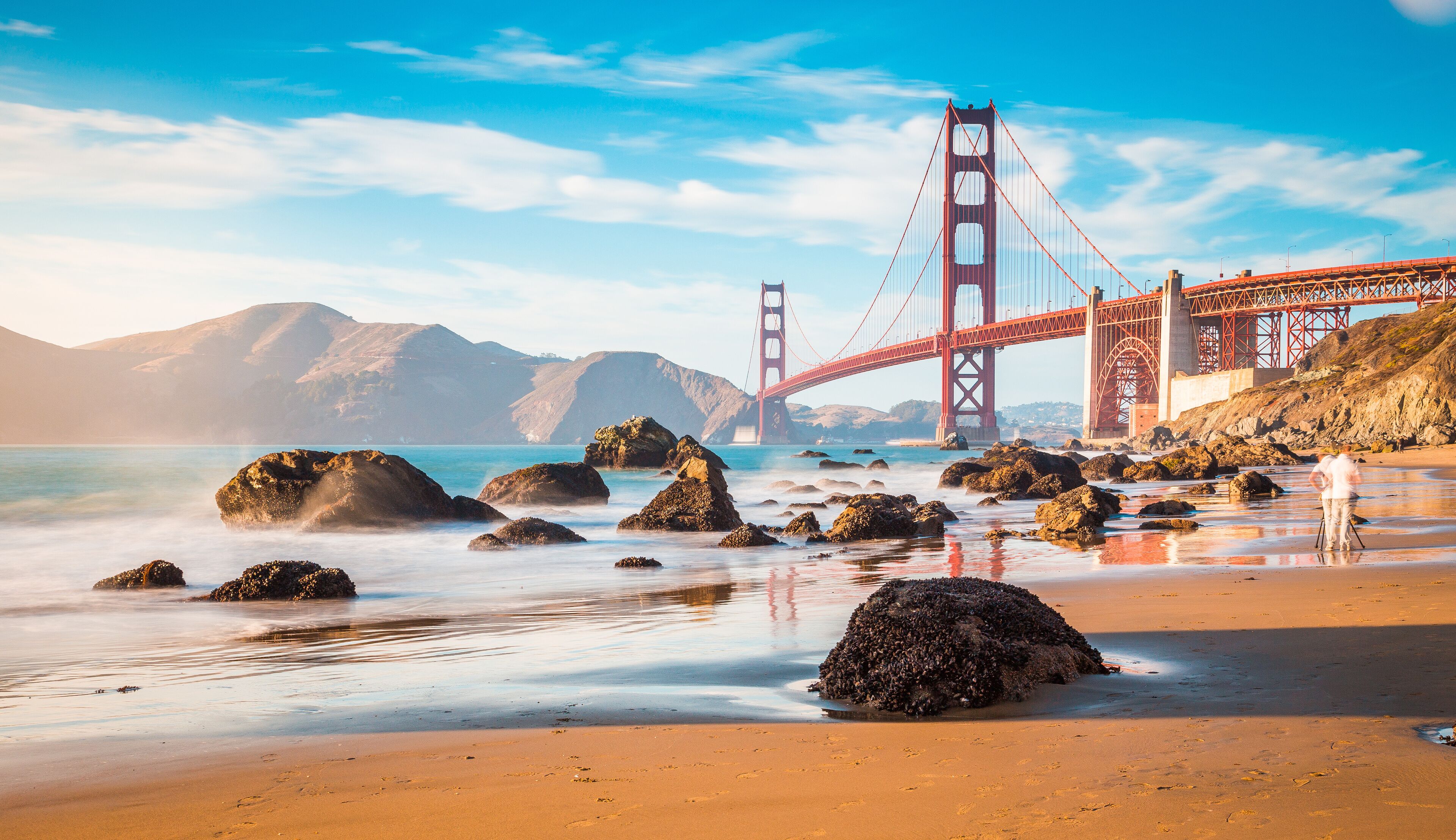 Une plage avec de gros rochers et une vue sur le pont du Golden Gate.
