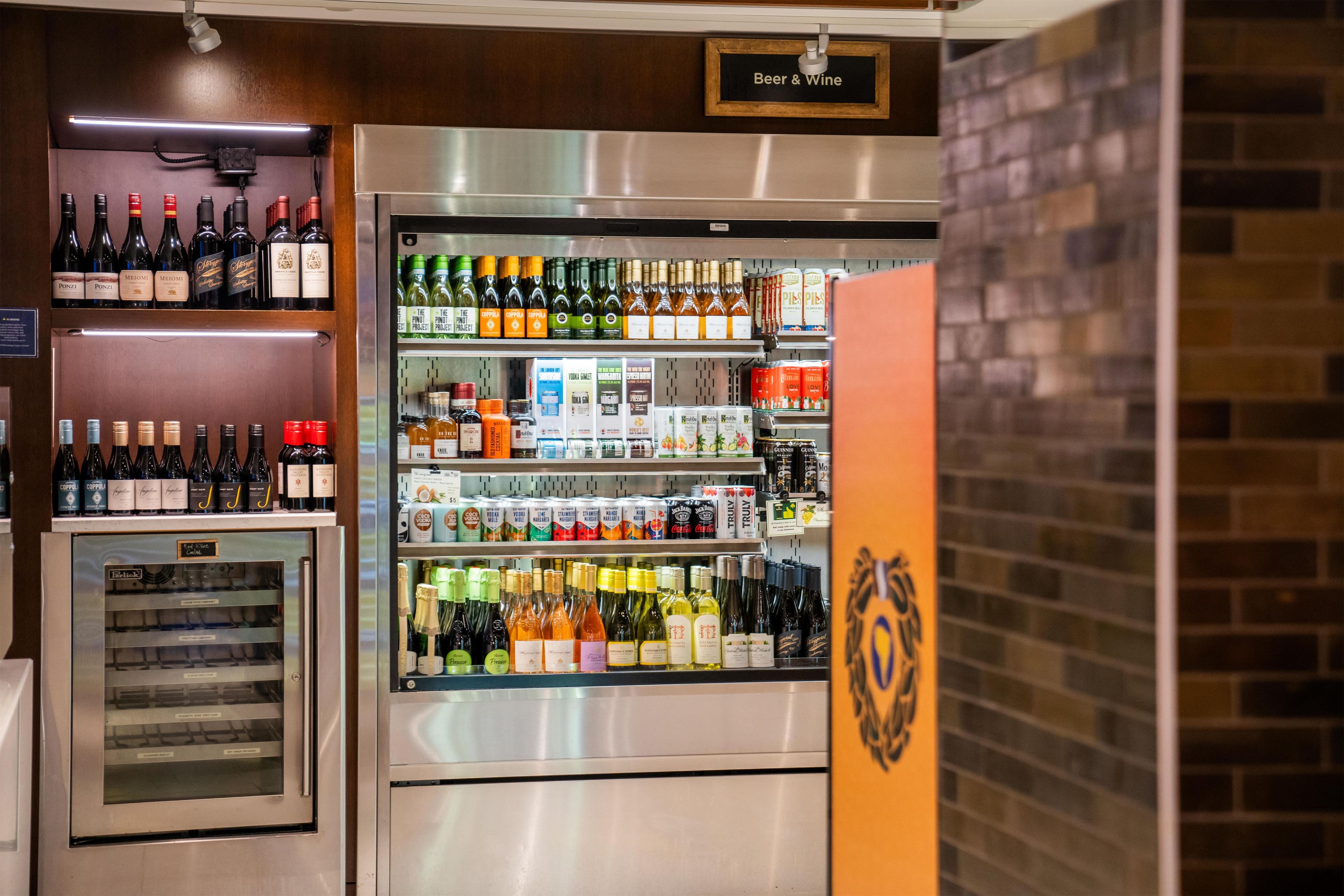Un réfrigérateur à boissons contenant une variété de boissons alcoolisées, notamment du vin, de la bière et des spiritueux.