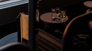 Un restaurante con vista a la ciudad, mesas con vasos y un menú.