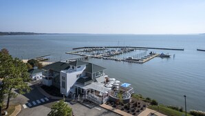 A waterfront property with a marina, a covered outdoor seating area, and a building with a modern design.