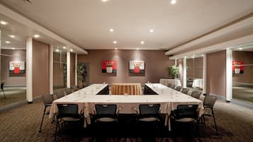 Une salle de conférence avec une longue table, des chaises et des œuvres d’art accrochées aux murs.