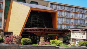 A hotel with a modern architectural design, featuring a prominent entrance with a wooden overhang and a sign that reads "Glenstone Lodge".