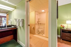 Un baño con ducha, inodoro y tocador con espejo.