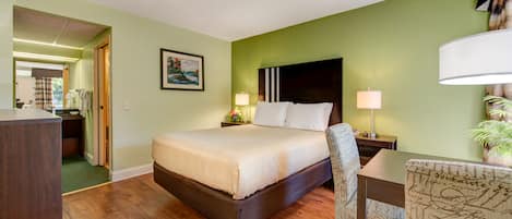 Una habitación de hotel con cama, mesitas de noche, escritorio y una silla.