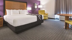 A hotel room with a large bed, a chair, a table, and a lamp. - La Quinta Inn by Wyndham Denver Westminster (Westminster)
