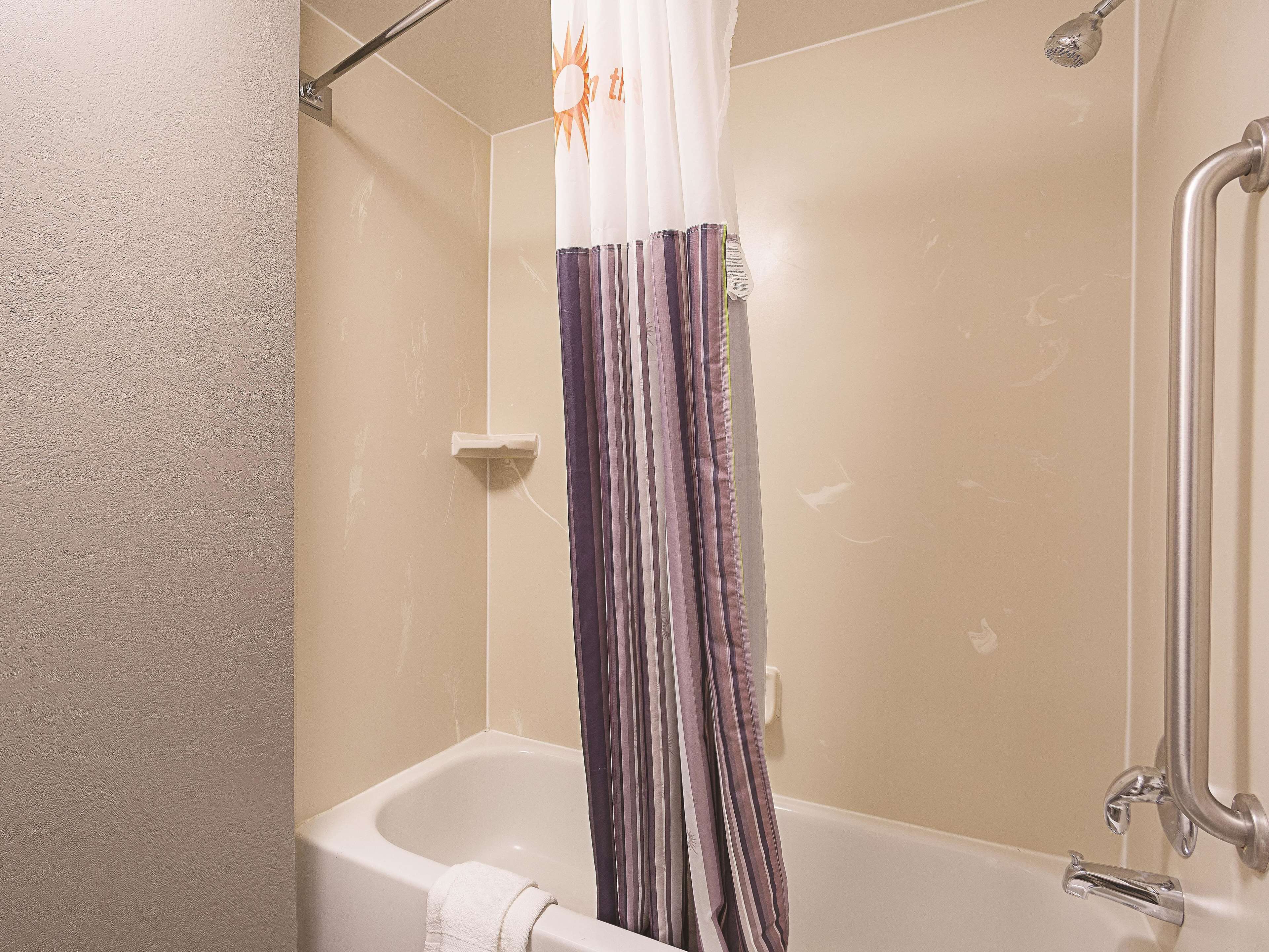 A bathroom with a bathtub, shower, and a curtain.