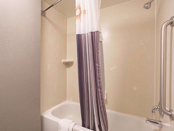 A bathroom with a bathtub, shower, and a curtain.