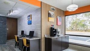 A modern reception area with two desks, a coffee machine, and a large window offering a view of the street.