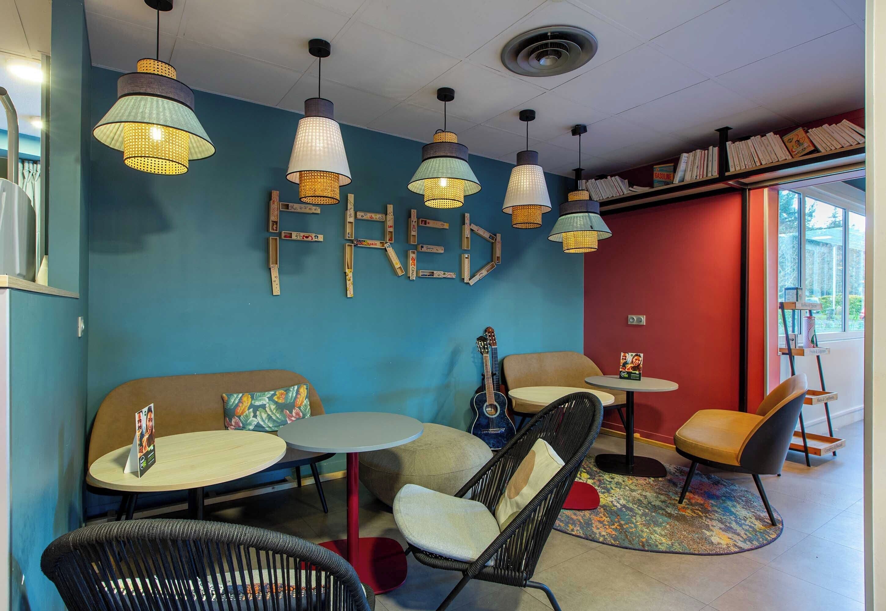 A cozy cafe with round tables, wicker chairs, and hanging pendant lights.