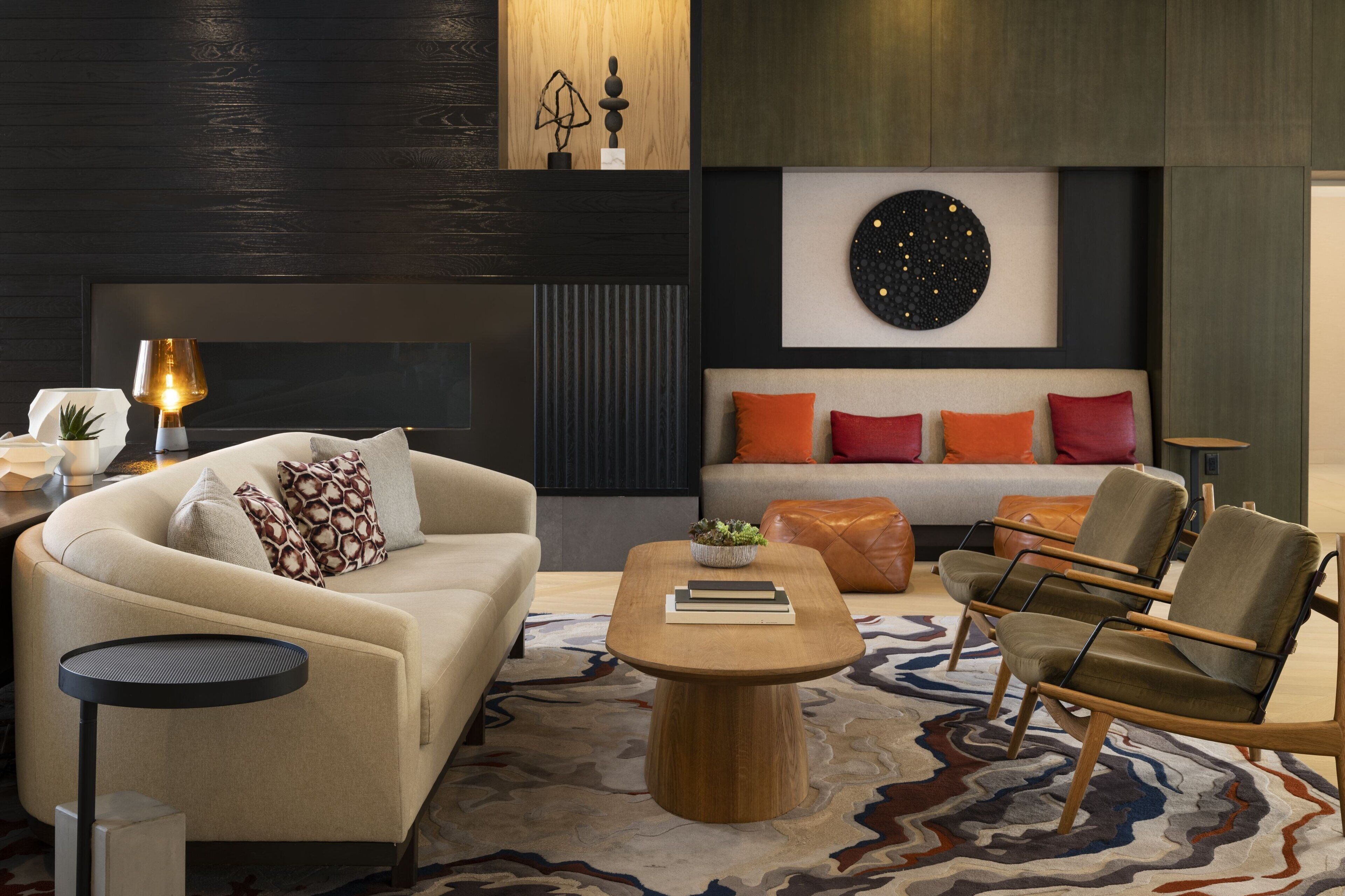Un salon moderne avec un canapé, des fauteuils, une table basse et une cheminée.