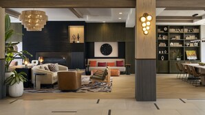 A modern living room with a fireplace, a sofa set, a dining area, and a bookshelf. - Napa Valley Marriott Hotel & Spa (Napa)