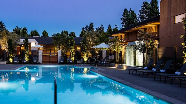 A swimming pool with lounge chairs and umbrellas, surrounded by buildings and trees. - Napa Valley Marriott Hotel & Spa (Napa)