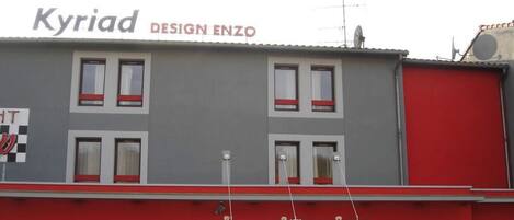 A building with a sign reading 'Kyriad DESIGN ENZO'.