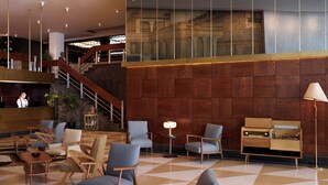 A lobby with a checkered floor, wooden paneling, and modern furniture including armchairs and a reception desk. - Brown Acropol, a Member of Brown Hotels (Athens)