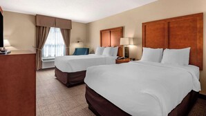 A hotel room with two beds, a desk, a chair, and a window with curtains. - Comfort Inn Augusta (Augusta)