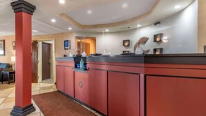 A reception area with a red reception desk, a brown carpet, and a clock on the wall. - Comfort Inn Augusta (Augusta)