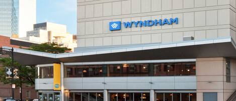 A building with a 'WYNDHAM' sign, featuring a modern architectural design with a flat roof and large windows.