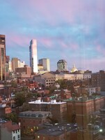 A city skyline with various buildings, including a prominent skyscraper and a historic building with a dome.