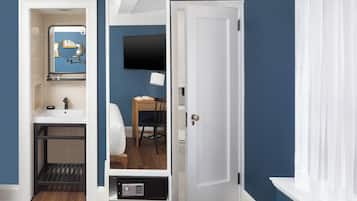 Una habitación con baño, escritorio y televisor.