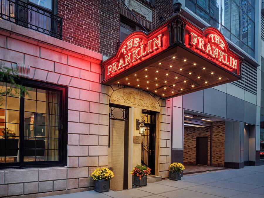 A theater marquee with the name 'The Franklin' and a brick facade with a large window.