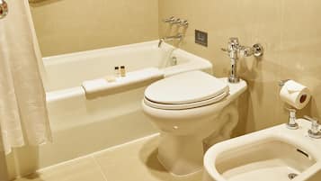 Un baño equipado con bañera, inodoro, bidé y zona de ducha.