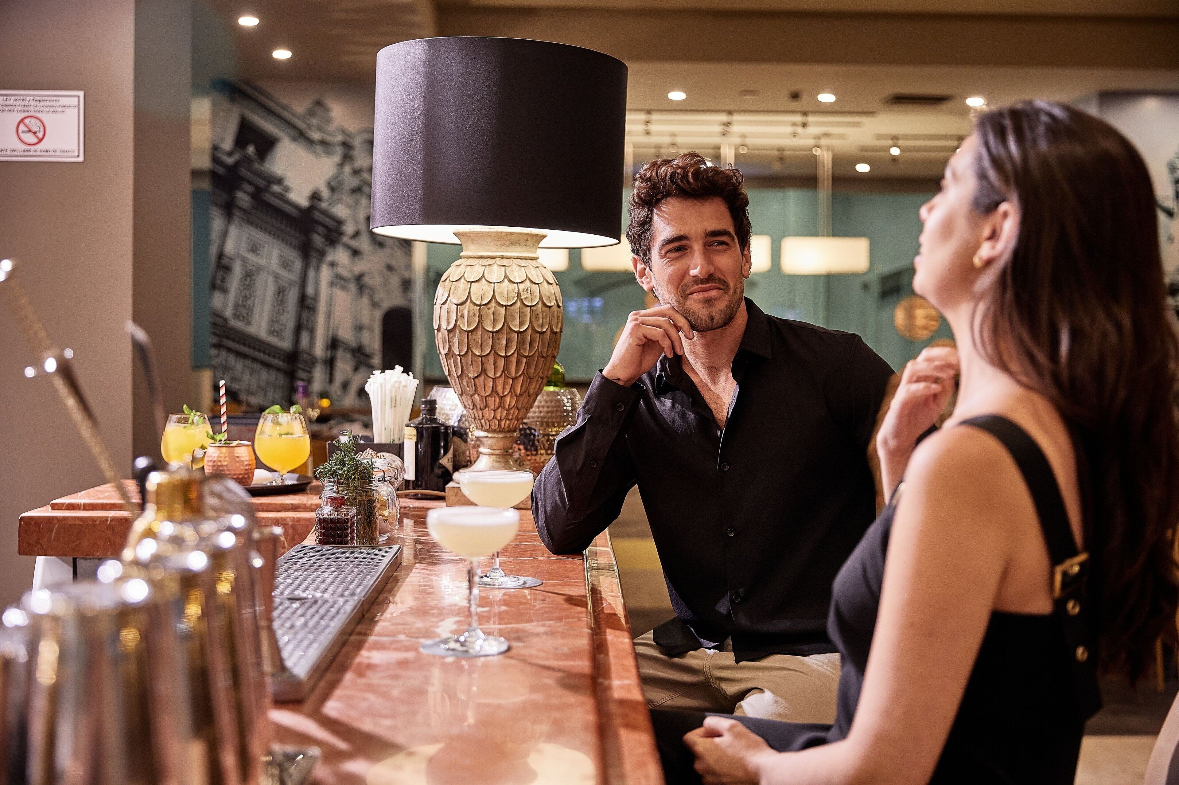 A bar area with a marble countertop, a decorative lamp, and a menu stand.