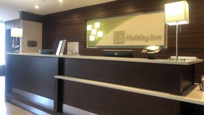 A reception desk at Holiday Inn with a digital display, a cash register, and a telephone. - Holiday Inn Charlottesville-Monticello by IHG (Charlottesville)