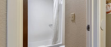 A bathroom with a bathtub, toilet, and shower curtain.