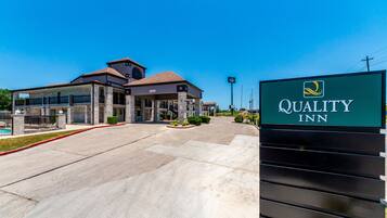A Quality Inn hotel with a clear entrance, a covered outdoor area, and a signboard.