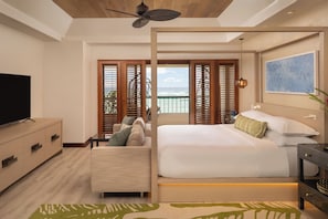A modern hotel room with a bed, a TV, a sofa, and a balcony with ocean views. - Sheraton Kauai Coconut Beach Resort (Kapaa)