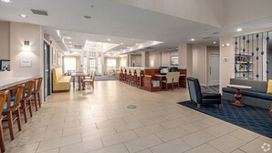 Um hall amplo com balcão de recepção, área de estar e bar.