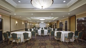 A conference room with round tables and chairs, a patterned carpet, and a chandelier. - Embassy Suites by Hilton Parsippany (Parsippany)