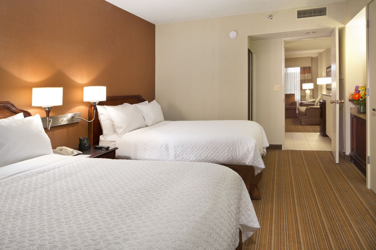 Ein Hotelzimmer mit zwei Betten, einem Nachttisch mit Telefon und einer Lampe.