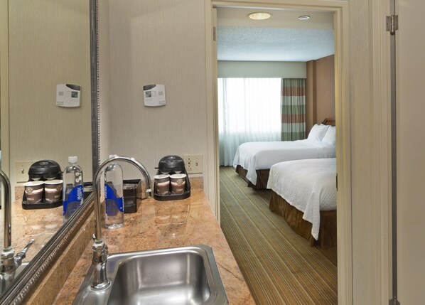 A hotel room with a sink, two beds, a coffee maker, and a mirror. - Embassy Suites by Hilton Parsippany (Parsippany)