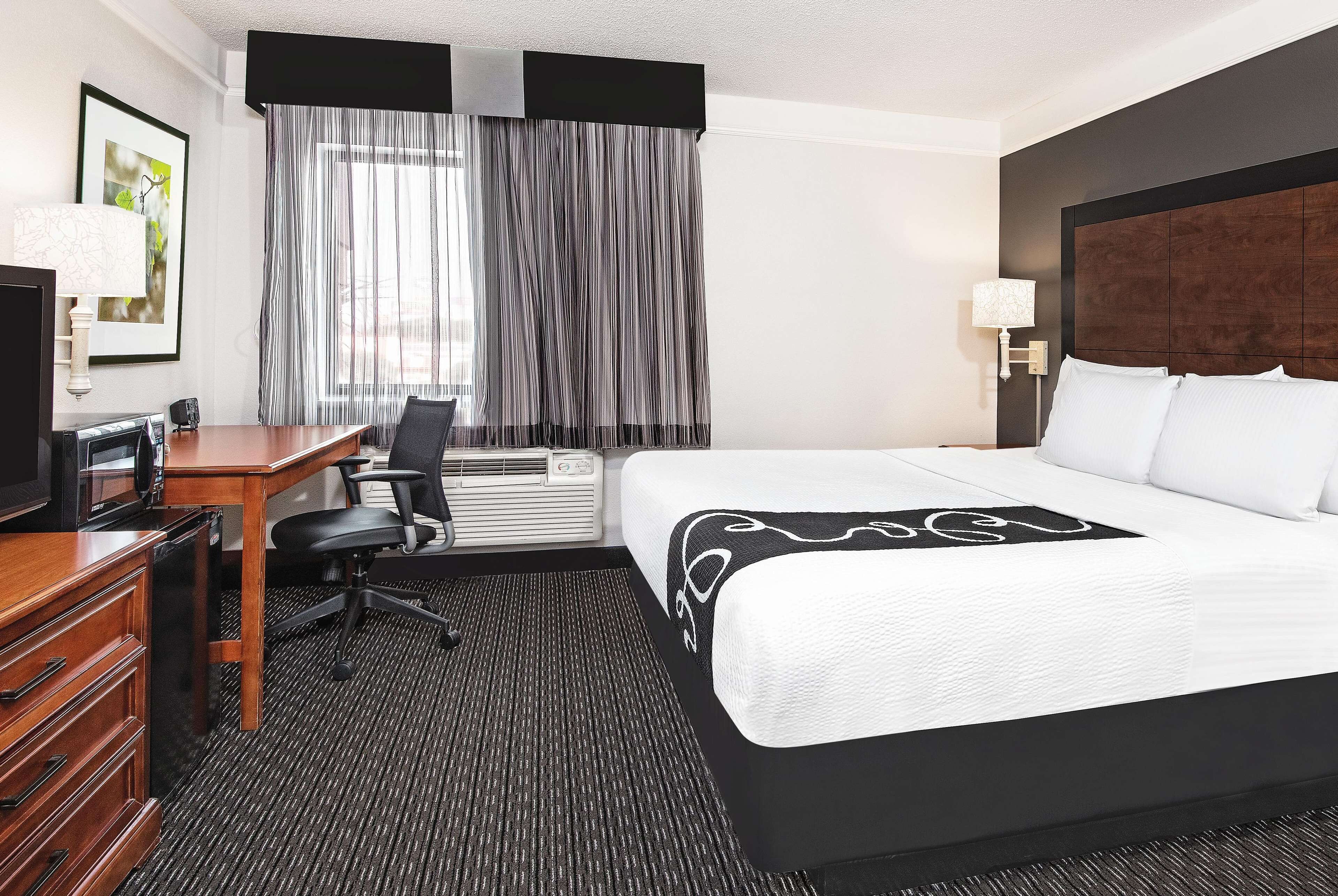 Une chambre d’hôtel équipée d’un lit, d’un bureau, d’une chaise et d’un téléviseur.