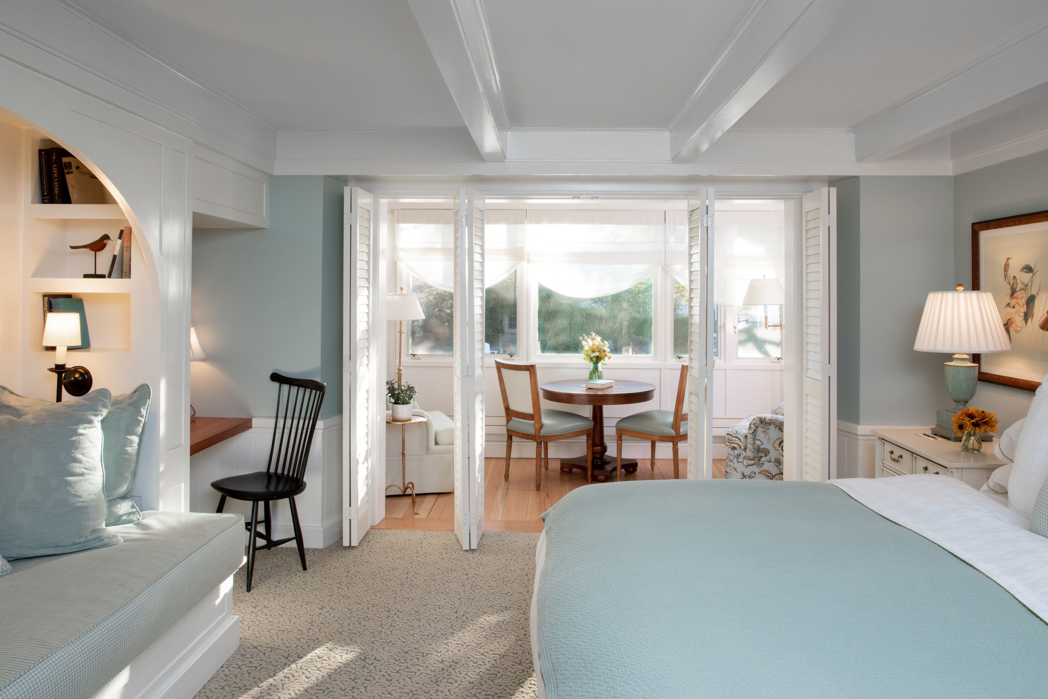 Une chambre à coucher avec un lit, un bureau, une chaise et une fenêtre.