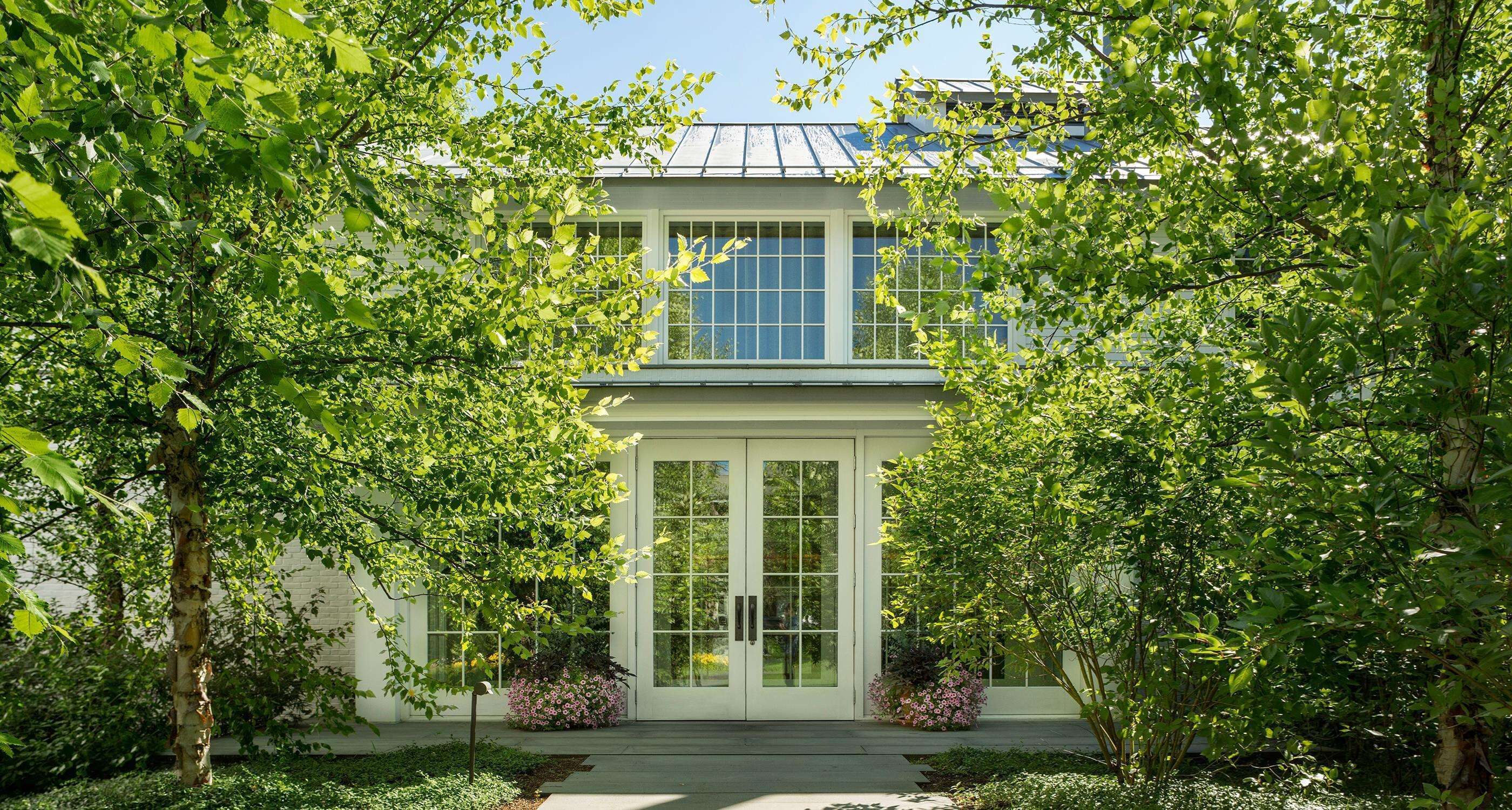 A two-story house with a symmetrical facade, large windows, and a covered porch.