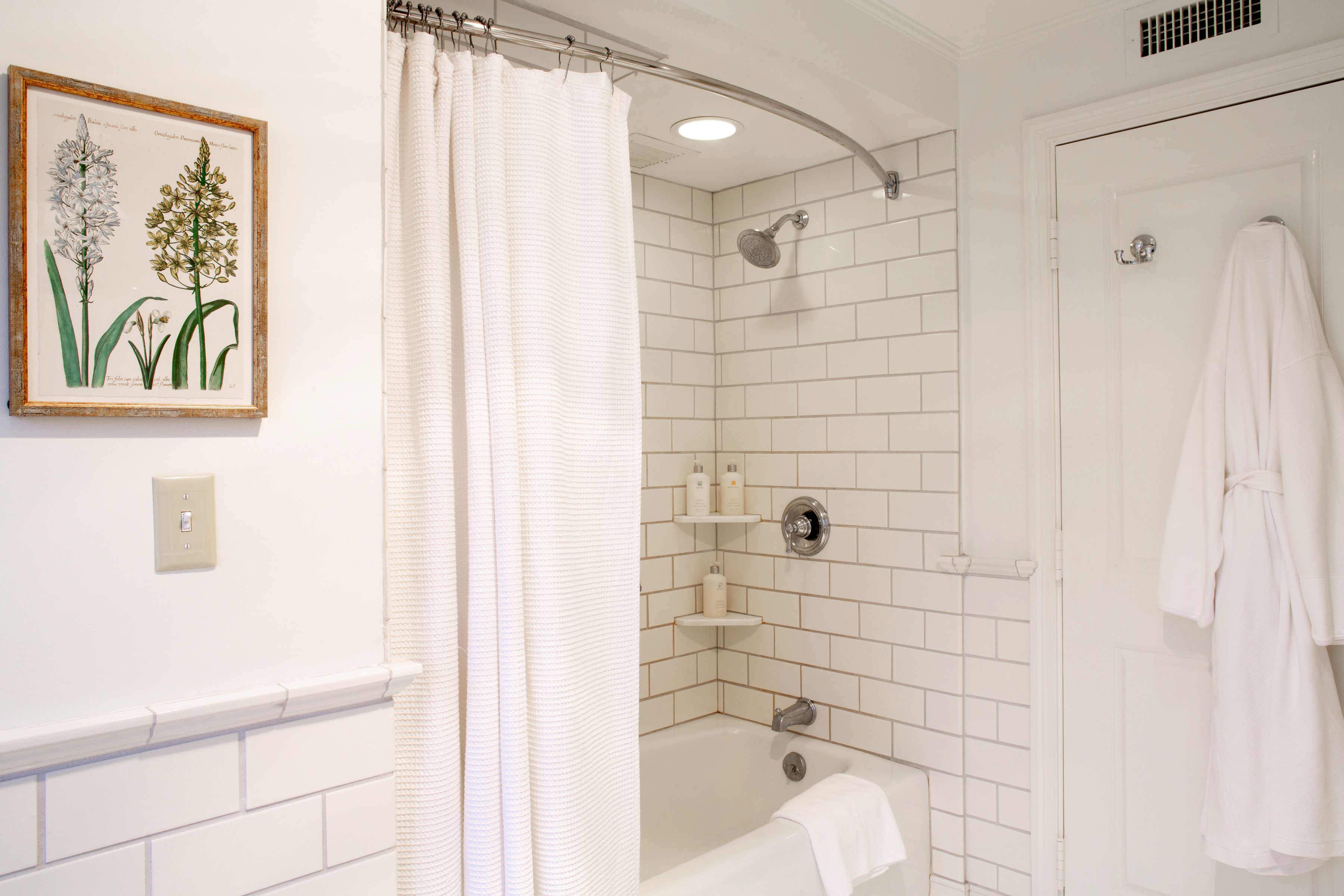 A bathroom with a shower, a bathtub, and a towel rack.